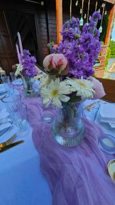 a vase filled with purple and white flowers on a table at Wysockie Zacisze in Osowa