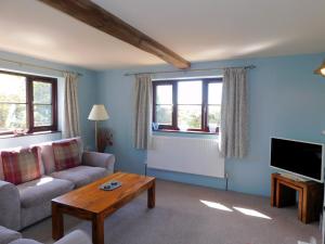a living room with a couch and a table at Beechwood Cottage in Filby