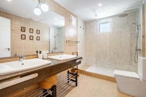 a bathroom with two sinks and a tub and a toilet at Villa Conguitosby 3VILLAS in Sant Lluis