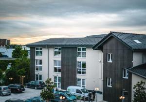 a building with cars parked in a parking lot at Steinberger Hof in Dietzenbach