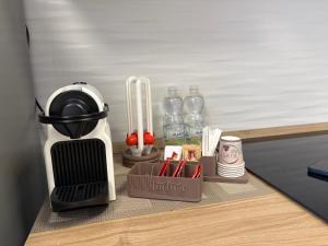 a kitchen counter with utensils and bottles of water at Malpensa Stay Express Self check-in in Gallarate