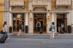 a group of people walking in front of a store at Hotel Moderno in Bari