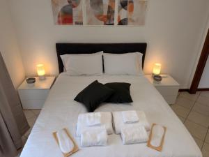 a bedroom with a large white bed with two lamps at Malpensa Stay Express Self check-in in Gallarate