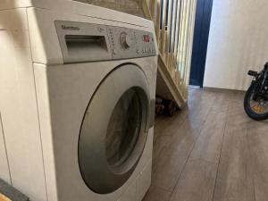 a white washing machine sitting in a laundry room at 4 winds Boreos 2 in Palanga