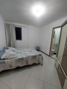 a bedroom with a bed in a white room at Apartamento em Guarapari in Guarapari