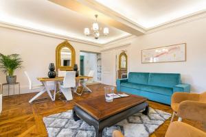 a living room with a blue couch and a table at Le Cote D'Or in Dijon