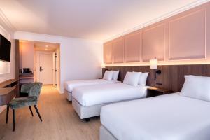 a hotel room with two beds and a television at Golden Tulip Hotel de’ Medici in Bruges +59 photos