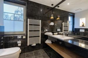 a bathroom with a sink and a toilet and a tub at Romantik Hotel Schwanefeld & Spa in Meerane +80 photos