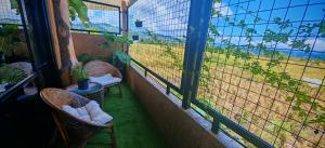 a balcony with two chairs and a window with a fence at GRG Stays-MatteoS in Santo Domingo