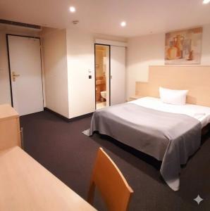 ein Hotelzimmer mit einem Bett und einem Stuhl in der Unterkunft Hotel Ross in Schweinfurt + 57 Fotos