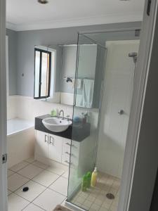 a bathroom with a glass shower and a sink at Coomera Private Rooms near DreamWorld in Gold Coast +12 photos