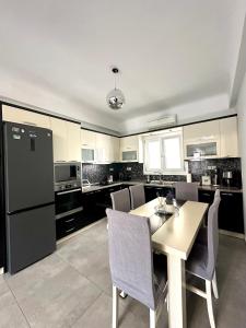 a kitchen with a table and chairs and a refrigerator at Arientas Apartment in Ermoupoli +4 photos
