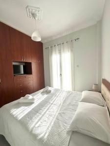 a bedroom with a large white bed with a television at Arientas Apartment in Ermoupoli