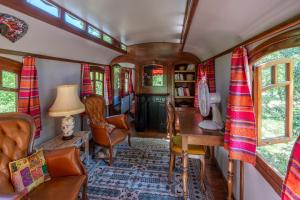 a train living room with a desk and chairs at La Roulotte Authentique in Grignan +19 photos