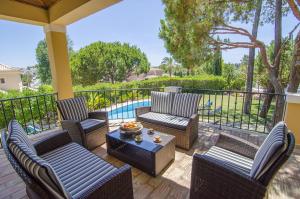 a patio with chairs and a table and a pool at Villa Lira by Algarve Holidays in Almancil
