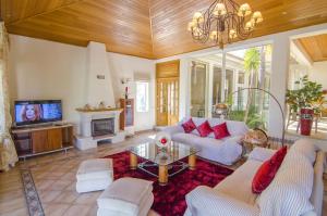a living room with a couch and a tv at Villa Lira by Algarve Holidays in Almancil