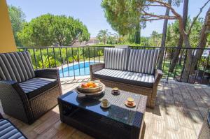 a patio with two chairs and a table with a bowl of fruit at Villa Lira by Algarve Holidays in Almancil