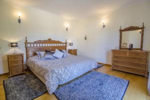 a bedroom with a bed and two dressers and a mirror at Villa Lira by Algarve Holidays in Almancil +30 photos