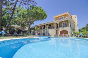 a large swimming pool in front of a house at Villa Lira by Algarve Holidays in Almancil