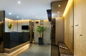 a living room with a couch and a plant at Hotel 81 Gold in Singapore