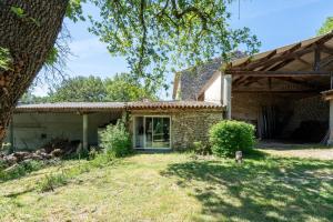 an old stone house with a tree in the yard at La Roulotte Authentique in Grignan