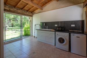 a kitchen with a washer and dryer in a room at La Roulotte Authentique in Grignan