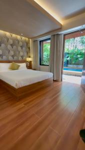 a bedroom with a large bed and a large window at Choox Villa Hotel in Koronadal