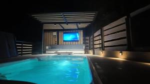 a large swimming pool with a television in the background at Silva Peak House in Zawoja