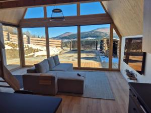 a living room with a couch and a large window at Silva Peak House in Zawoja