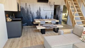 a living room with a table and a kitchen at Silva Peak House in Zawoja