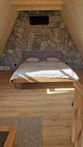 a bed in a room with a stone wall at Silva Peak House in Zawoja +19 photos