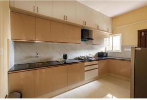 a large kitchen with white cabinets and black counter tops at Mahadev grand in Tirupati