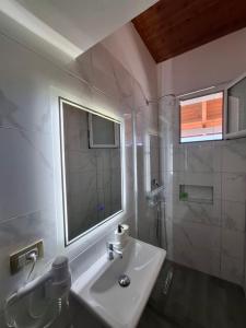 a white bathroom with a sink and a window at Yard Paradise Rooms in Dhërmi +163 photos