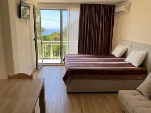 a hotel room with a bed and a balcony at Villa Blanca in Petrovac na Moru