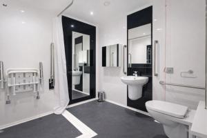 a white bathroom with two sinks and a toilet at Destiny - Burnet Point in Edinburgh +31 photos