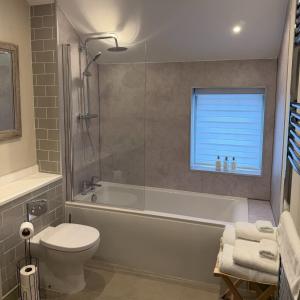 a bathroom with a tub and a toilet and a sink at The Old Kings Head in Boston +84 photos