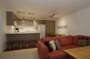 een woonkamer met een rode bank en een keuken bij Lawlers 9 in Mount Hotham