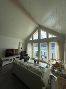 a living room with a couch and a television at Sea house in beautiful surroundings in Haram