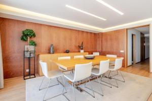 a dining room with a wooden table and white chairs at Beachouse Pvz - Seafront By Pomerania in Póvoa de Varzim