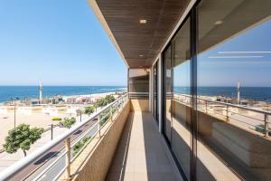 a view of the beach from the balcony of a building at Beachouse Pvz - Seafront By Pomerania in Póvoa de Varzim