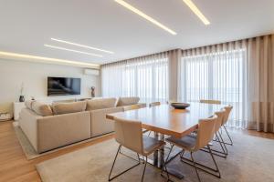 a dining room with a table and a couch at Beachouse Pvz - Seafront By Pomerania in Póvoa de Varzim