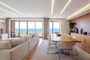 a living room with a couch and a table with chairs at Beachouse Pvz - Seafront By Pomerania in Póvoa de Varzim +36 photos
