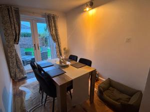 a dining room with a table and chairs and a window at Holly Berry Cottage in Holme next the Sea