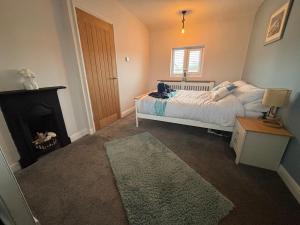 a bedroom with a bed with a fireplace and a bed sidx sidx sidx at Holly Berry Cottage in Holme next the Sea