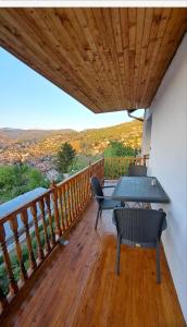 a balcony with a table and chairs on a deck at Panorama Sky Apartment -11 min by walk to Old Town - Free Parking in Sarajevo