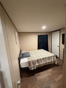 a small bedroom with a bed with a plaid blanket at The Relaxation Haven  +8 photos