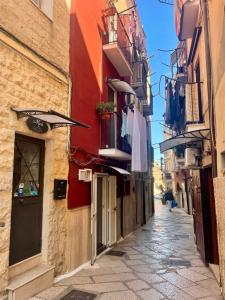 a narrow alley with clothes hanging from buildings at Marè Rooms Bari old town center in Bari
