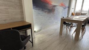 a dining room with a table and chairs and a painting at Spacious modern loft on Perfetskogo in Lviv +8 photos