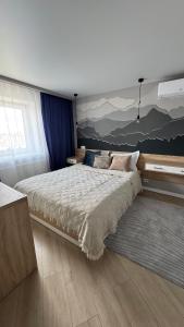 a bedroom with a large bed with a painting on the wall at Spacious modern loft on Perfetskogo in Lviv