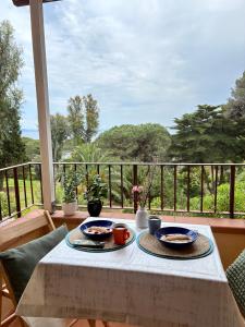 a table with two plates of food on a balcony at Capo d'Arco Residence Bilocale tra Mare e Natura in Capo D'Arco